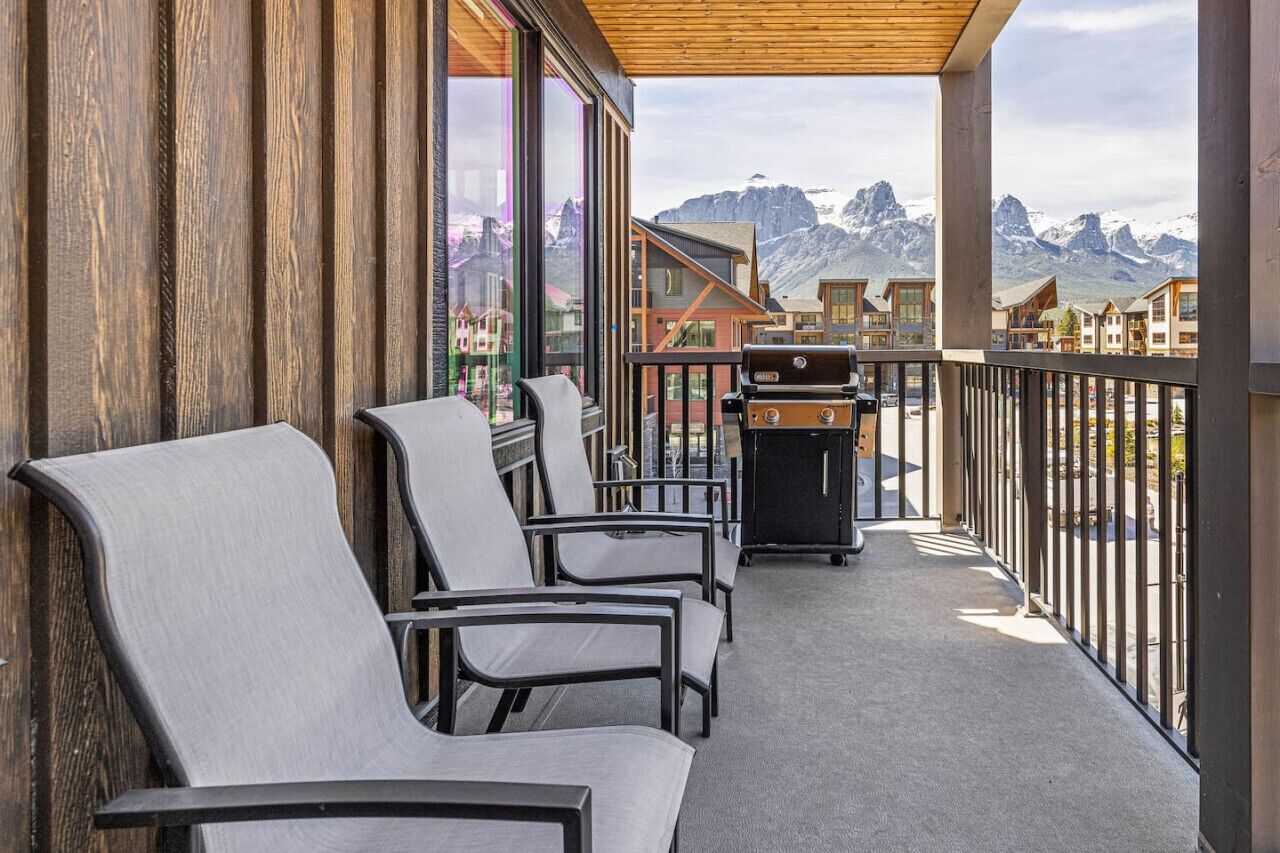 Ein Balkon mit Sitzgelegenheit, Grill und Bergblick.
