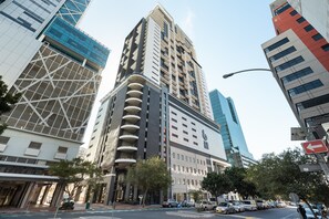 Ein modernes Hochhaus mit einer markanten Glasfassade und einem einzigartigen geometrischen Design.
