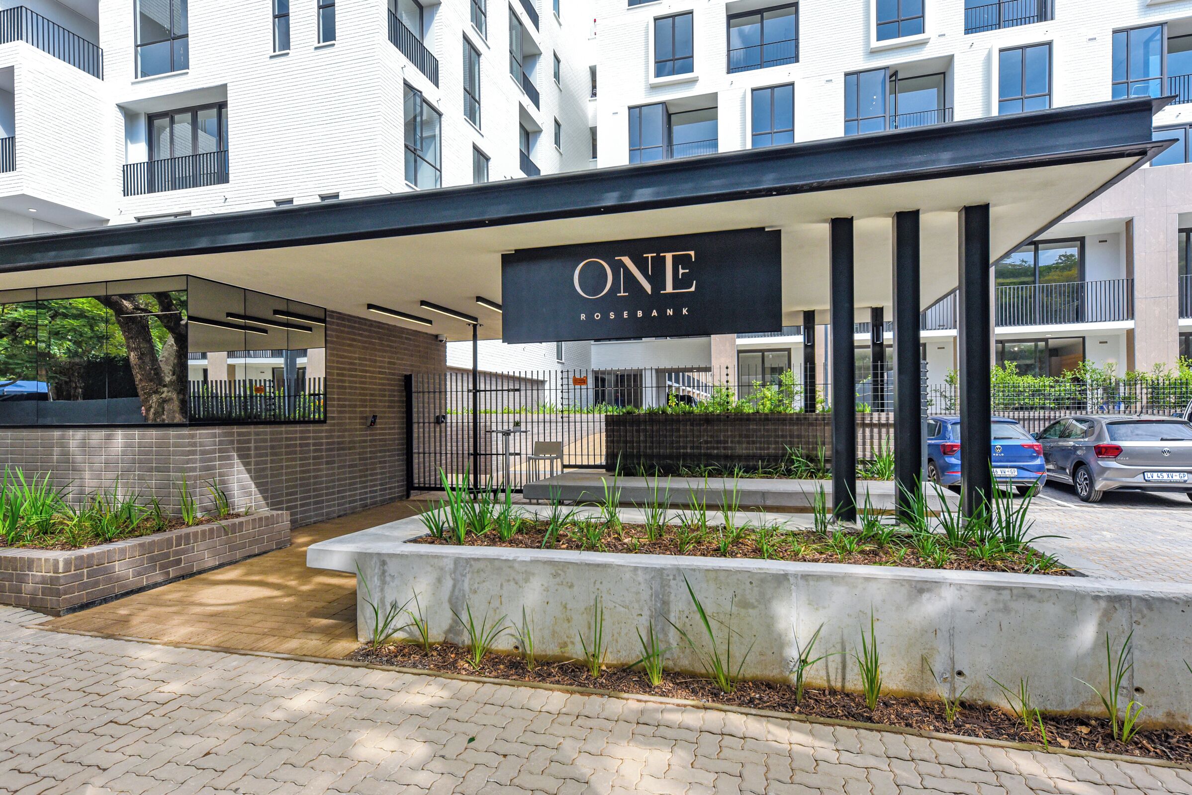 Un edificio moderno con un cartello che riporta la scritta 'ONE ROSEBANK'.
