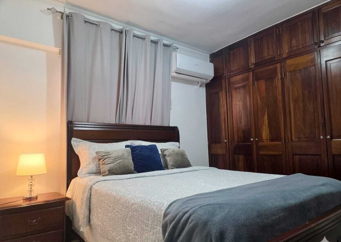 Ein Schlafzimmer mit Bett, Nachttisch und Kleiderschrank.