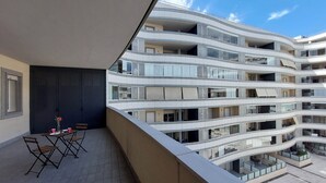 Um edifício com várias andares, varandas e terraços.