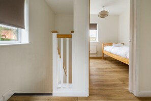 Ein Zimmer mit einem Holzbett, einem Heizkörper und einem Fenster.
