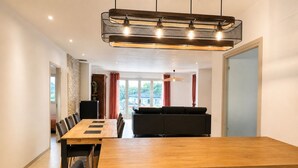 Un comedor moderno con una mesa de madera, sillas negras y un sofá negro.