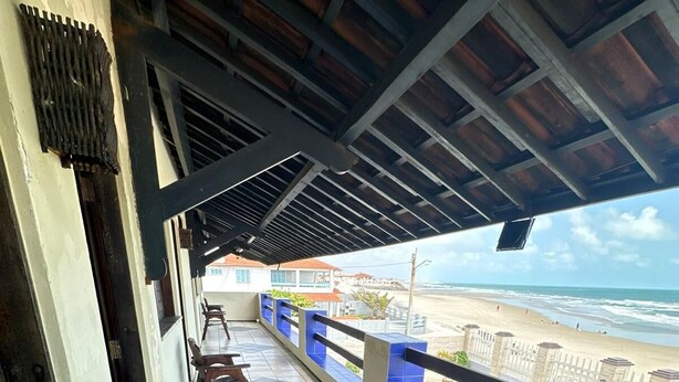 Un'area salotto esterna coperta con vista sulla spiaggia e sull'oceano.