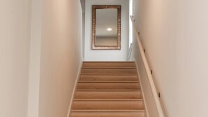 Een trap met houten treden en een witte muur.