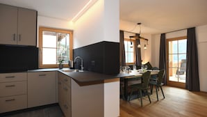 Moderni keittiö, jossa on ruokailutila, puulattia ja suuret ikkunat.