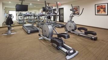 A gym with treadmills, elliptical machines, and stationary bikes.