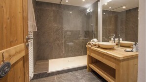 A modern bathroom with a shower, a wooden vanity, and a large mirror. - Chalet-like triplex with separate entrance ideal for large families (Les Contamines-Montjoie)