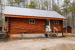 A log cabin with a metal roof, a front door, and a small porch with steps. - Long Pond Cabin Retreat (Denmark)