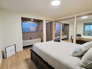 Ein Schlafzimmer mit einem großen Bett, Meerblick und einem Spiegel.