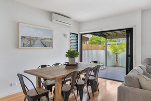 Comedor con una mesa de madera, sillas y una planta en maceta.
