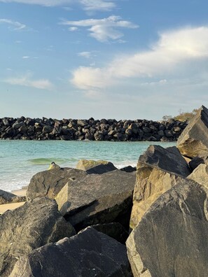 Una costa rocosa con grandes rocas y un mar tranquilo.