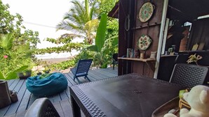 Patio esterno con tavolo, sedie e un pouf.