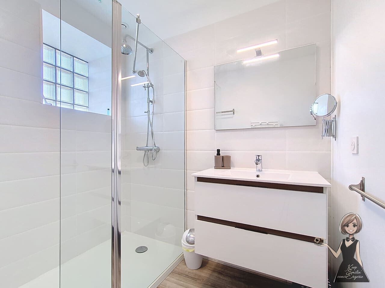 A modern bathroom with a glass shower enclosure, a white vanity with a mirror, and a toilet.