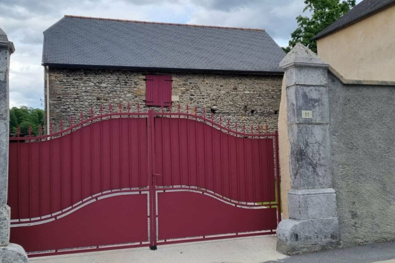 Ein Steinhaus mit einem roten Metallgitter.