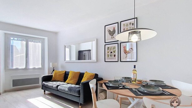 A modern living room with a sofa, dining table, and chairs, a large window, and framed botanical prints on the wall. - La petite Maison Rouge, Charm and Nature in Béarn (Igon)