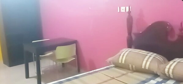 Una habitación con cama, escritorio y silla.