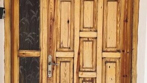 Une porte en bois avec un panneau de verre et une poignée en métal.