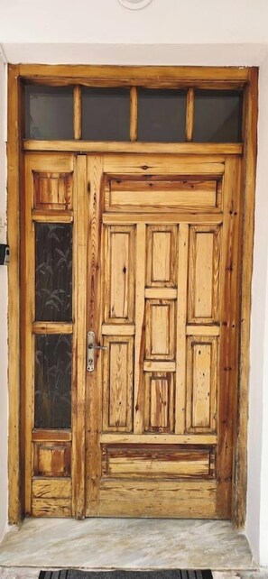 Eine Holztür mit Glasscheibe und Metallbeschlag.