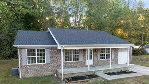 A single-story house with a brick exterior, a garage, and a covered porch.