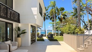 A modern outdoor living area with a pool, lounge chairs, and a view of the ocean. - Villa Paradiso (San Juan)