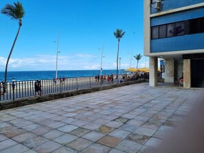 A paved walkway with a railing, palm trees, and a view of the ocean. - Barra Lighthouse. SPACIOUS. Feet in the sand. SEA VIEW. (Salvador)