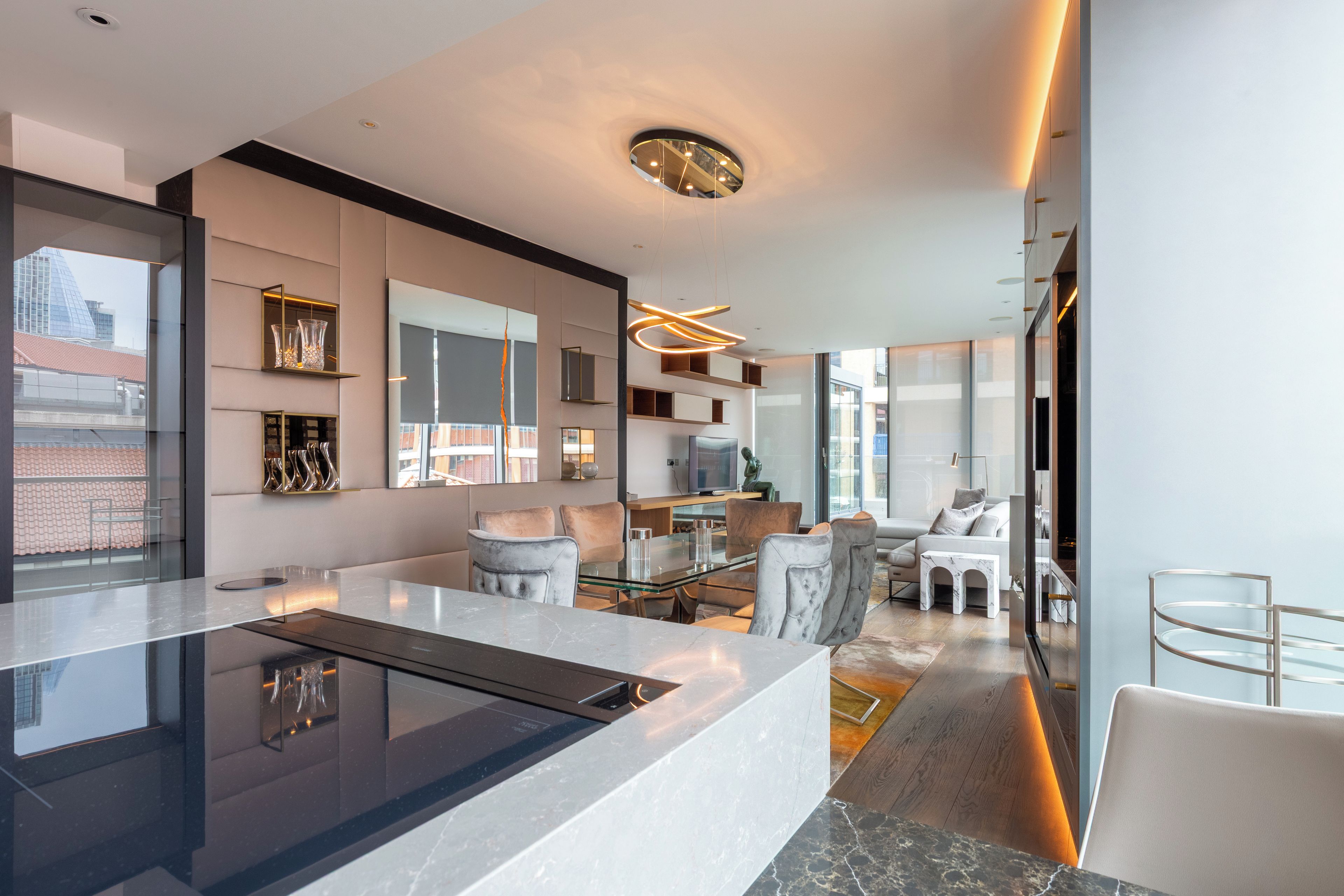 Una cucina moderna con isola centrale, elettrodomestici integrati e un'ampia finestra che offre vista sulla città.