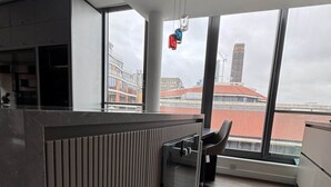 Et moderne køkken med et stort vindue, indbygget mikroovn og udsigt til bybilledet.