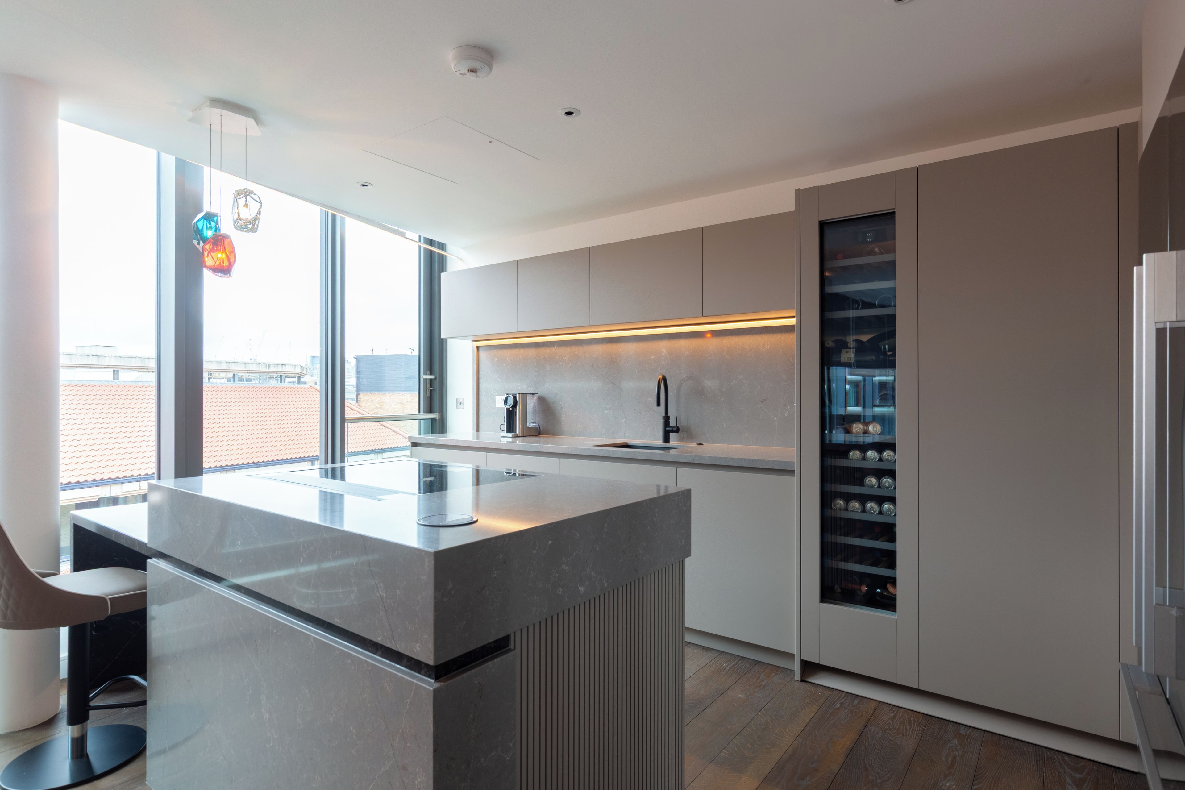 Una cucina moderna con isola centrale, elettrodomestici integrati e vista sulla città.