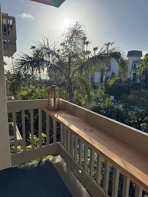 Ein Balkon mit Holzbalkon, einem kleinen Tisch und einer Laterne.