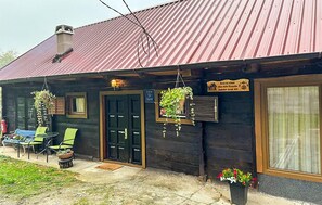 A rustic wooden building with a metal roof, a black door, and a sign indicating a hotel. - Stunning home in Hrascina with sauna (Hrascina)