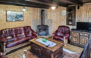 A rustic living room with leather sofas, a wooden coffee table, a stone fireplace, and a television. - Pet friendly home in Karlovac with WiFi (Karlovac)