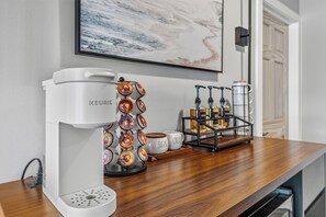 A coffee machine with a coffee pod holder and a coffee maker on a wooden countertop. - NEW*Lakefront-Private Chef-Beach + Kayaks-WI Dells (New Lisbon)