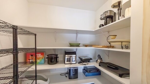 Cozinha com cafeteira, torradeira, chaleira e caixa de cereal.