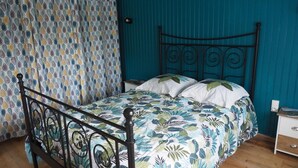 Ein Schlafzimmer mit einem Bett, einem Nachttisch und einem Vorhang.