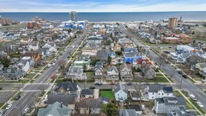An aerial view of a residential area with houses, streets, and a large building in the distance.
