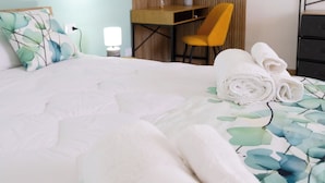 Une chambre à coucher comprenant un lit, un bureau, une chaise et une commode.