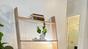 Ein Holztisch mit Stuhl, Blumentopf und Lampe.