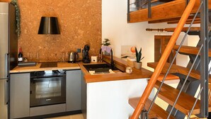 Una cocina compacta con horno Bosch, cafetera y lavabo.