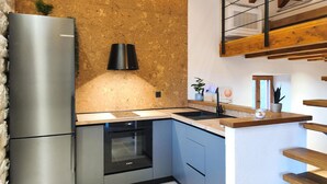 Una cocina con refrigerador de acero inoxidable, lavavajillas Bosch y encimera de madera.