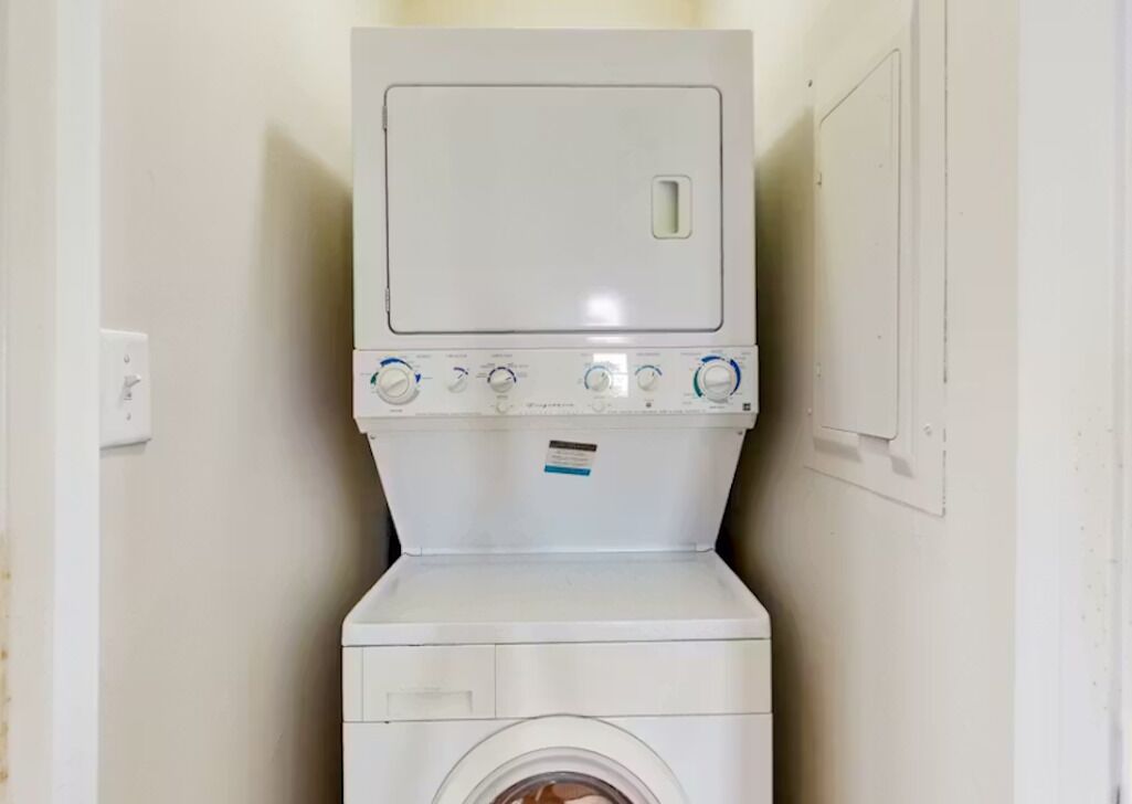 Eine weiße Waschmaschine mit Bedienfeld und Tür.