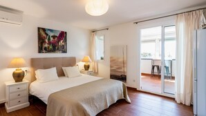 A bedroom with a bed, bedside lamps, a radiator, a window, and a view of the outside. - Casa Jetty - Three Bedroom Apartment, Sleeps 7 (Sitges)