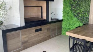 Una cucina moderna con griglia integrata, lavello e un giardino verticale verde.