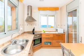 A modern kitchen with a stainless steel sink, a built-in oven, a microwave, and a window with a view of the outdoors. - Villa Alizee - Four Bedroom Villa, Sleeps 9 (Olèrdola)