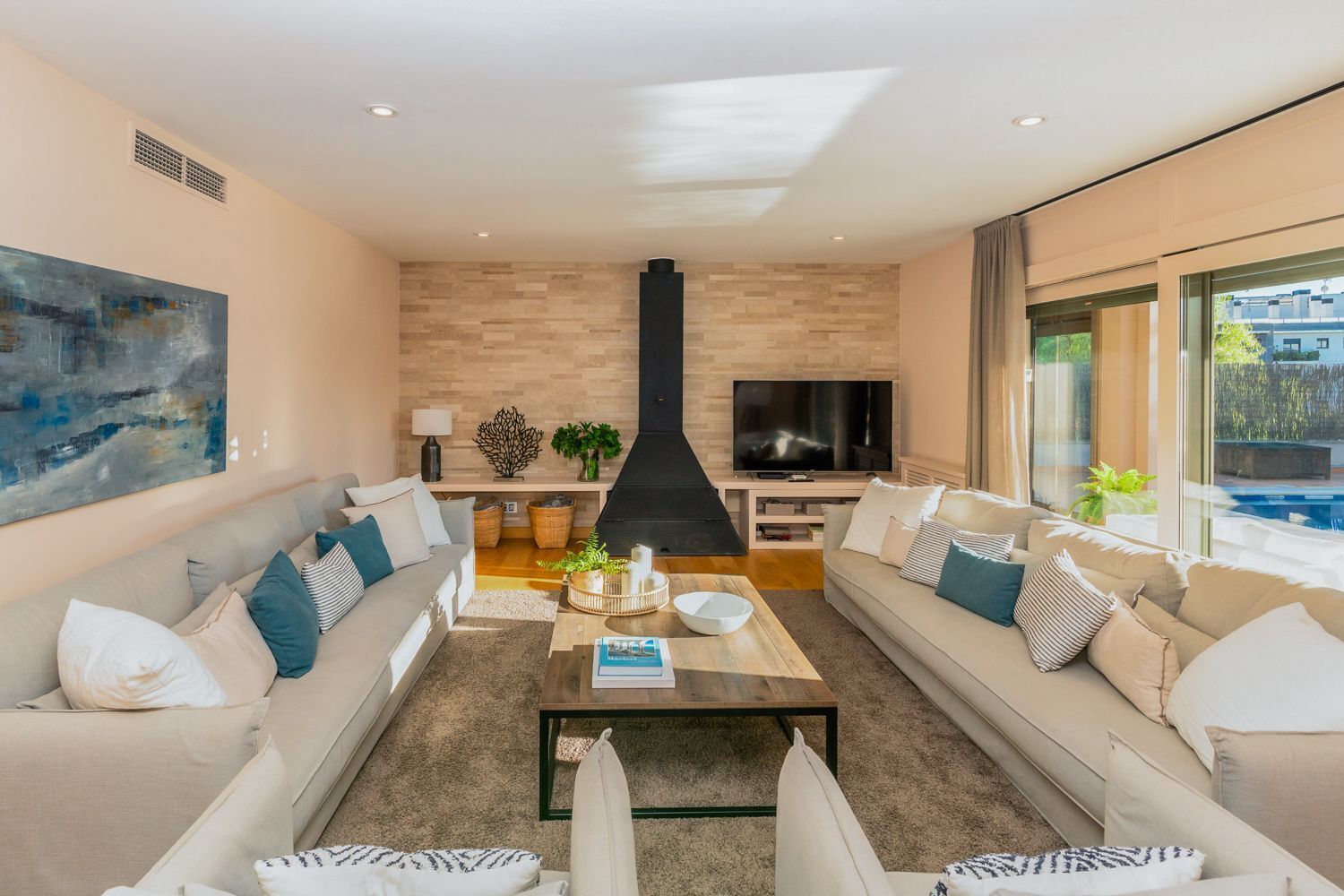 Un salon moderne avec une cheminée, des canapés, une table basse et un téléviseur.