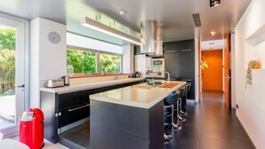 Een moderne keuken met een centraal eiland, een magnetron en een spoelbak.