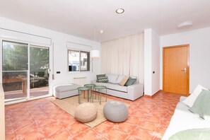 Ein modernes Wohnzimmer mit einer Couch, einem kleinen Tisch und zwei Poufs.