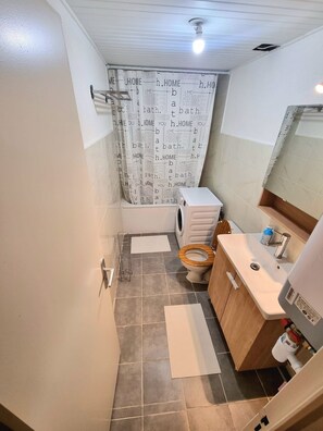 A bathroom with a toilet, sink, and shower curtain with text.