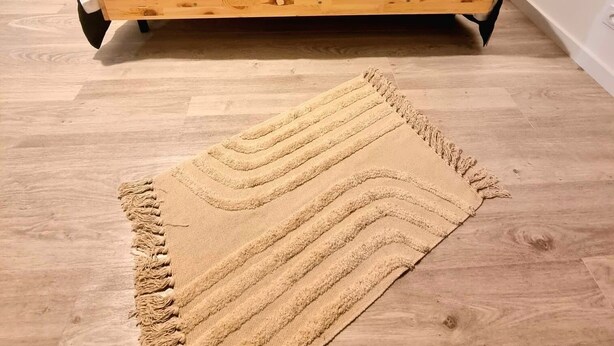 Una cama con estructura de madera, cabecera y dos lámparas de noche.