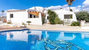 A white villa with a swimming pool, surrounded by greenery and palm trees. - Villa Caliza I - Four Bedroom Villa, Sleeps 8 (Cunit)
